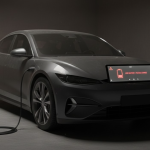 Hình ảnh xe điện đỗ lâu ngày trong garage, pin báo đỏ 0%, dây sạc chưa cắm.